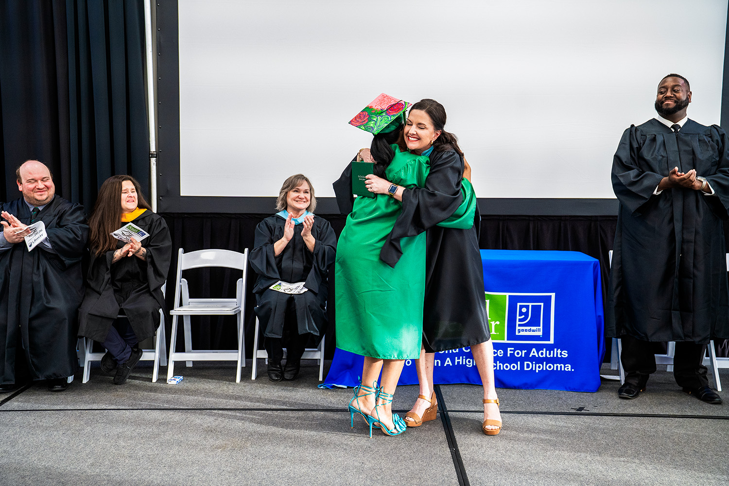 Hugging on stage at The Excel Center graduation